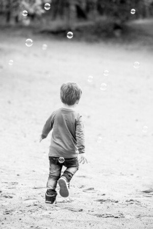 kind fotografie buitenspelen kinderfotografie bellenblaas weglopend