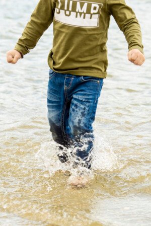 kind fotografie buitenspelen kinderfotografie water spetteren in water lopen