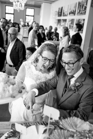 bruiloft bruidsfotografie samen bruidstaart snijden